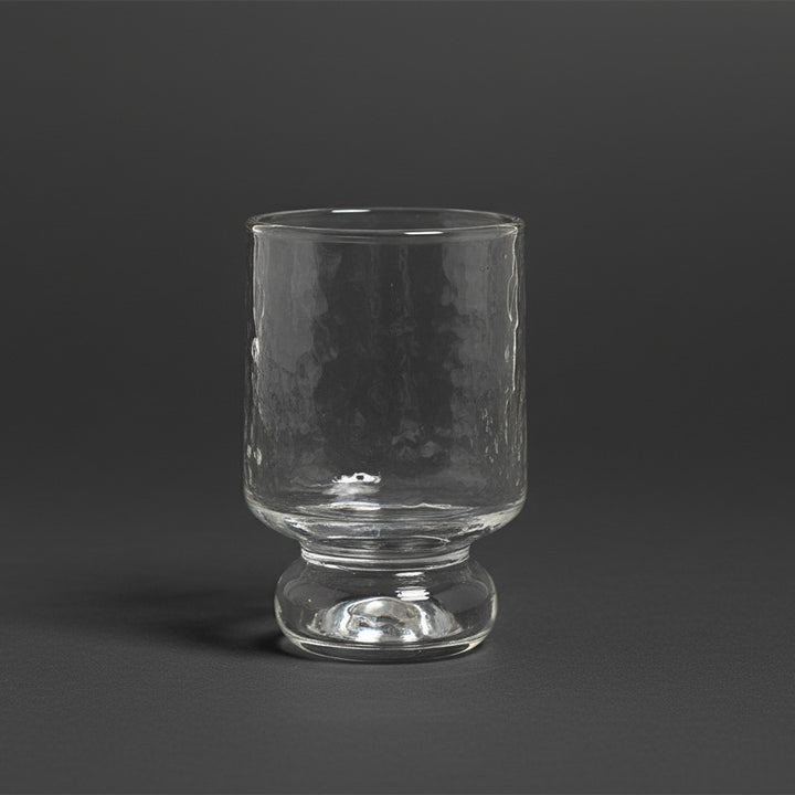 Stilvolles Weinglas aus gehämmertem Glas mit stabilem Standfuß.