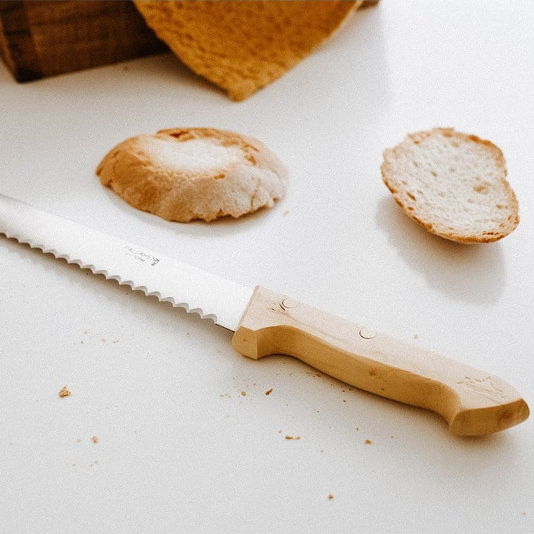Brotmesser mit Wellenschliff beim Schneiden von Baguette