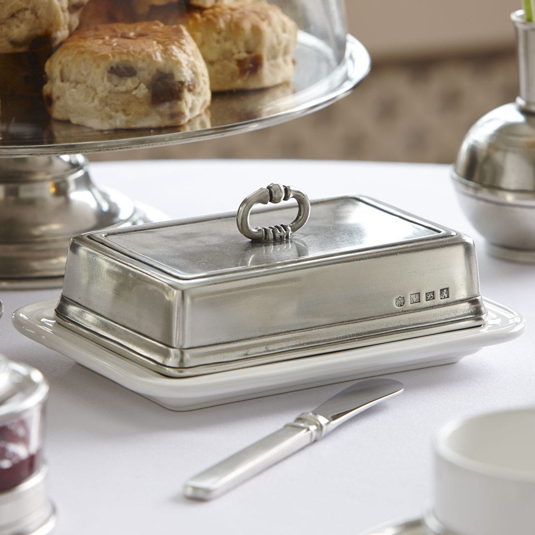 Butterdose aus Keramik und Zinn beim Servieren von Butter