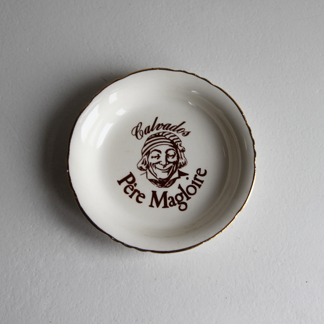 Weiße Calvados Père Magloire Keramikschale mit braunem Markenlogo, lächelndem Gesicht und gewelltem Goldrand, Frankreich 1970er Jahre.