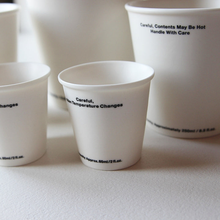 Detailaufnahme mehrerer Ceramic Not Paper Cup Keramikbecher in Form klassischer Pappbecher.