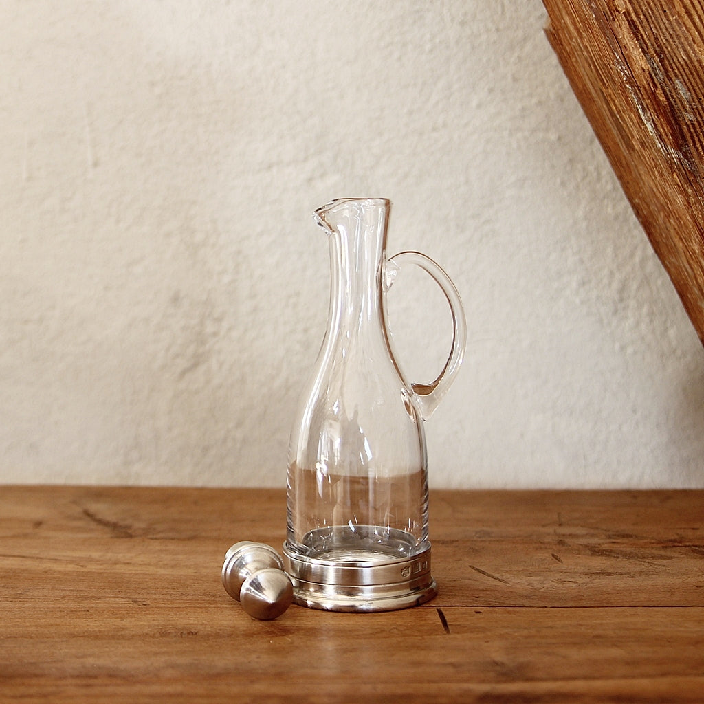 Essig- und Öl Karaffe aus Glas mit Zinn und Henkel in heller Umgebung