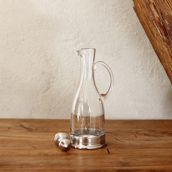 Essig- und Öl Karaffe aus Glas mit Zinn und Henkel in heller Umgebung