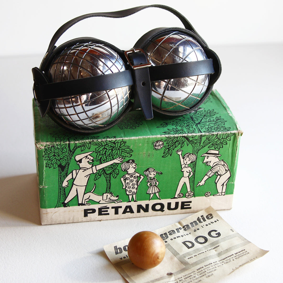 Altes französisches Boule-Set mit zwei Metallkugeln, schwarzem Lederträger, grünem Originalkarton, Holzkugel und Garantieschein.