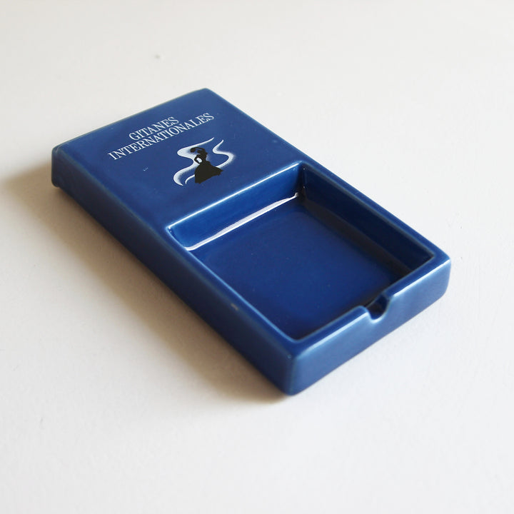Blaue Gitanes Internationales Ablageschale aus Keramik mit weißem Schriftzug und schwarzem Gitanes-Motiv.
