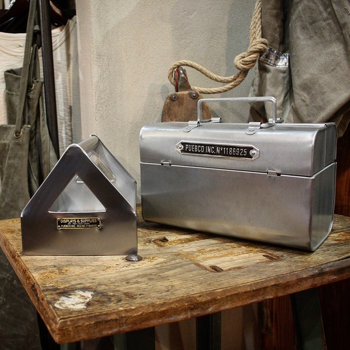 Iron Tool Box aus recyceltem Stahl von Puebco auf einem Holztisch neben weiterem Industrie-Accessoire