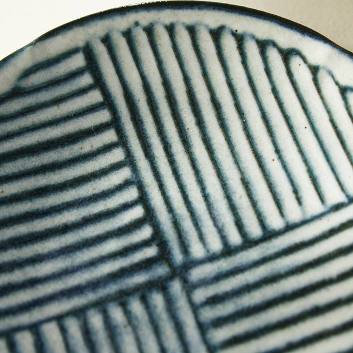 Detail eines japanischen Tellers mit feinem Linienmuster in Blau