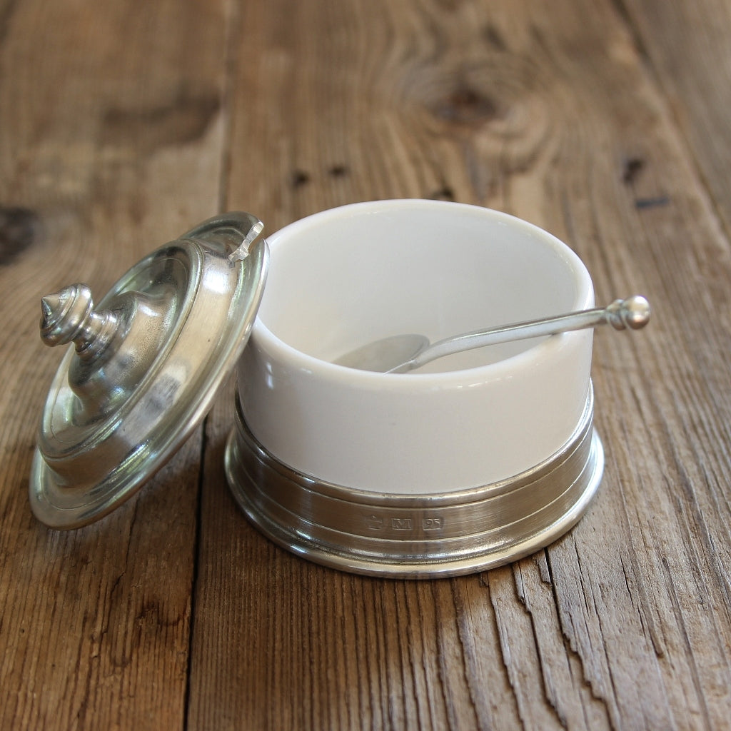 Geöffnete Marmeladendose aus Keramik mit Zinnlöffel