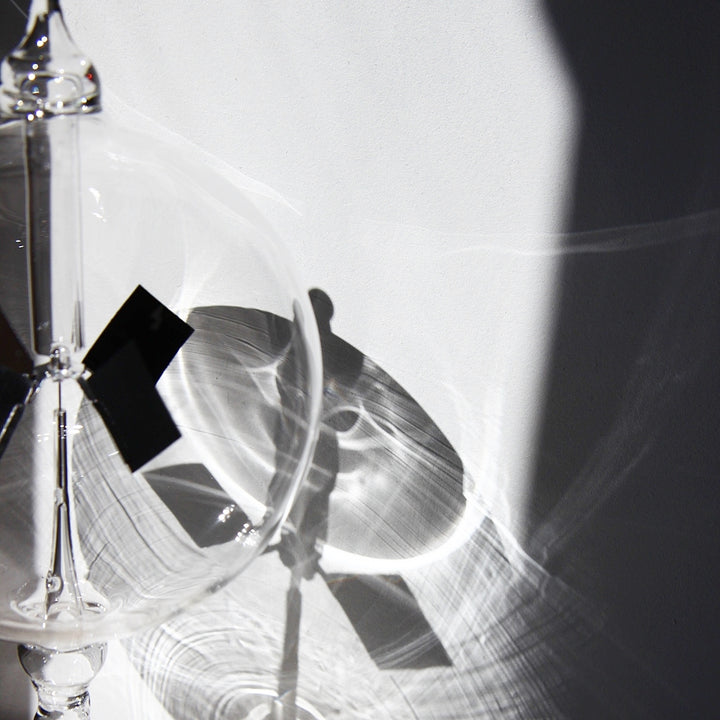 Radiometer aus Glas mit Lichtreflexen und rotierendem Flügelrad als wissenschaftliches Designobjekt