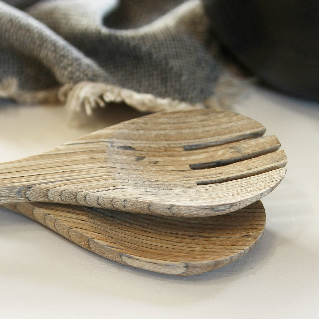 Detailaufnahme von Bambus Salatbesteck beim Servieren auf Holzbrett