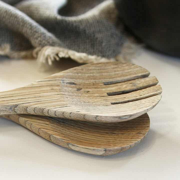 Detailaufnahme von Bambus Salatbesteck beim Servieren auf Holzbrett