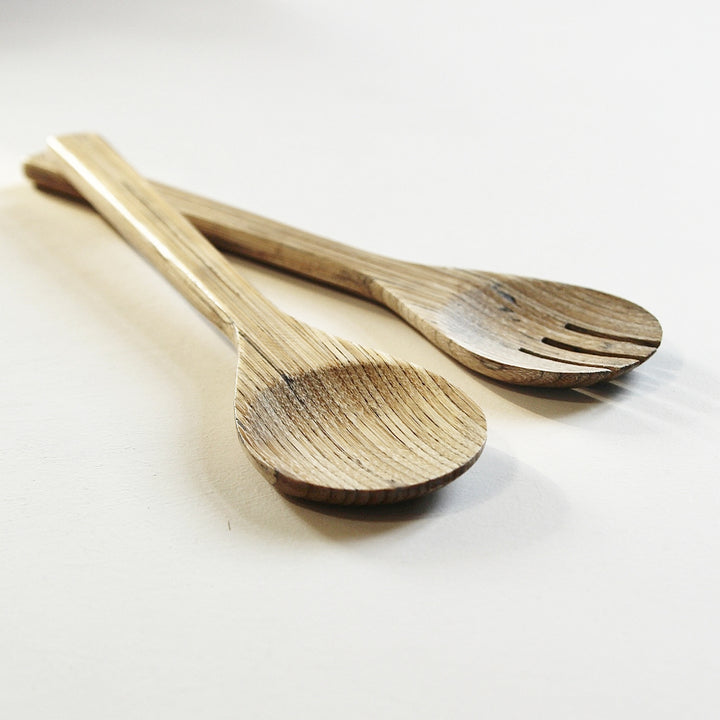 Salatbesteck aus Bambusholz mit Löffel und Gabel auf hellem Hintergrund