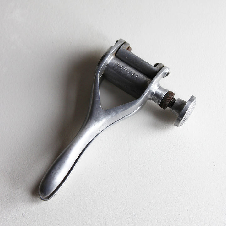 Alter französischer SANBRI Flaschenkorker aus Aluminium mit ergonomischem Griff, dunkler Korkenaufnahme und seitlichem Schraubmechanismus.