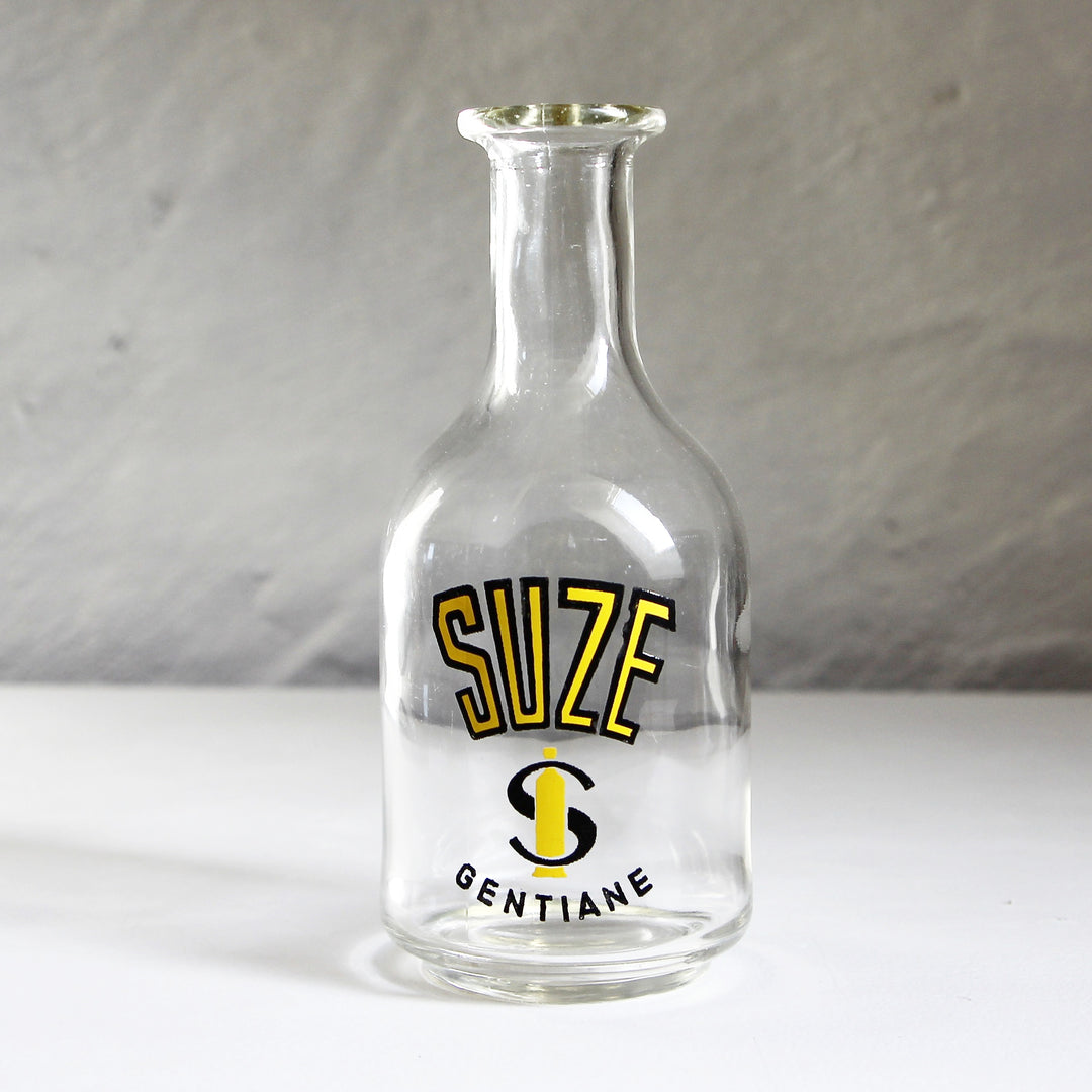 Alte französische Suze Gentiane Wasserkaraffe aus klarem Glas mit gelb-schwarzem SUZE Schriftzug und S-Logo.