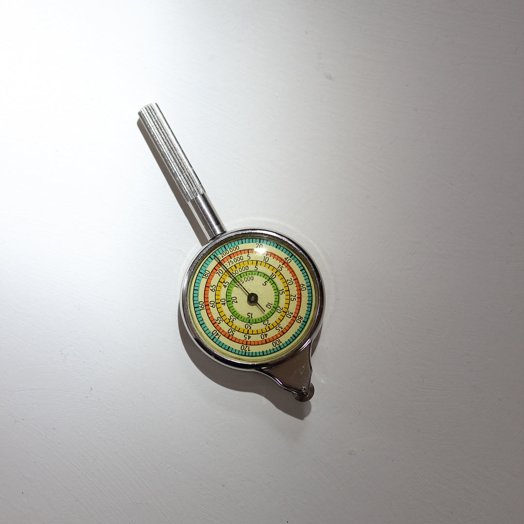 Vintage Kurvimeter aus Metall mit farbigem Zifferblatt zur mechanischen Entfernungsmessung auf Landkarten, gefertigt in den 1960er bis 1970er Jahren.