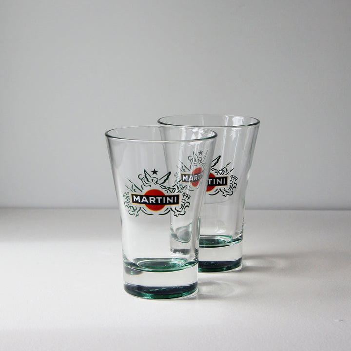 Zwei originale Vintage Martini & Rossi Longdrinkgläser mit grünem Glasboden und klassischem Martini-Logo aus den 1990er Jahren.