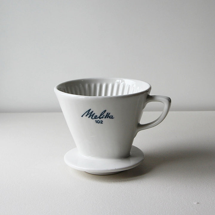 Vintage Melitta Kaffeefilter 102 aus weißem Porzellan mit blauem Logo für klassischen Handfilterkaffee.