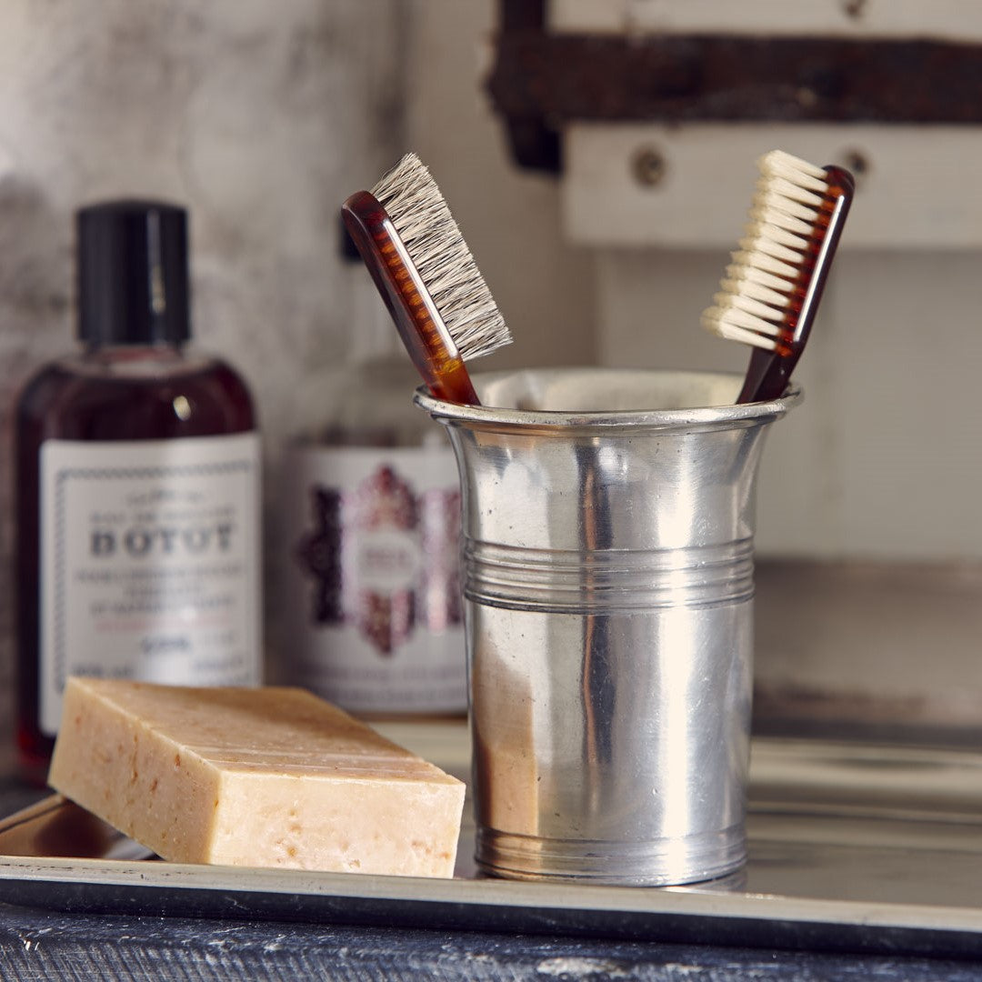Zahnbürstenbecher aus Hartzinn im Badezimmer mit Zahnbürste